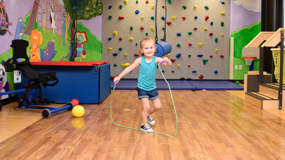 Child jumping rope in gym area