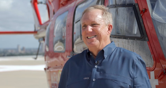 Memorial Hermann Life Flight patient, Brian Bremser, stands near a life-saving helicopter.